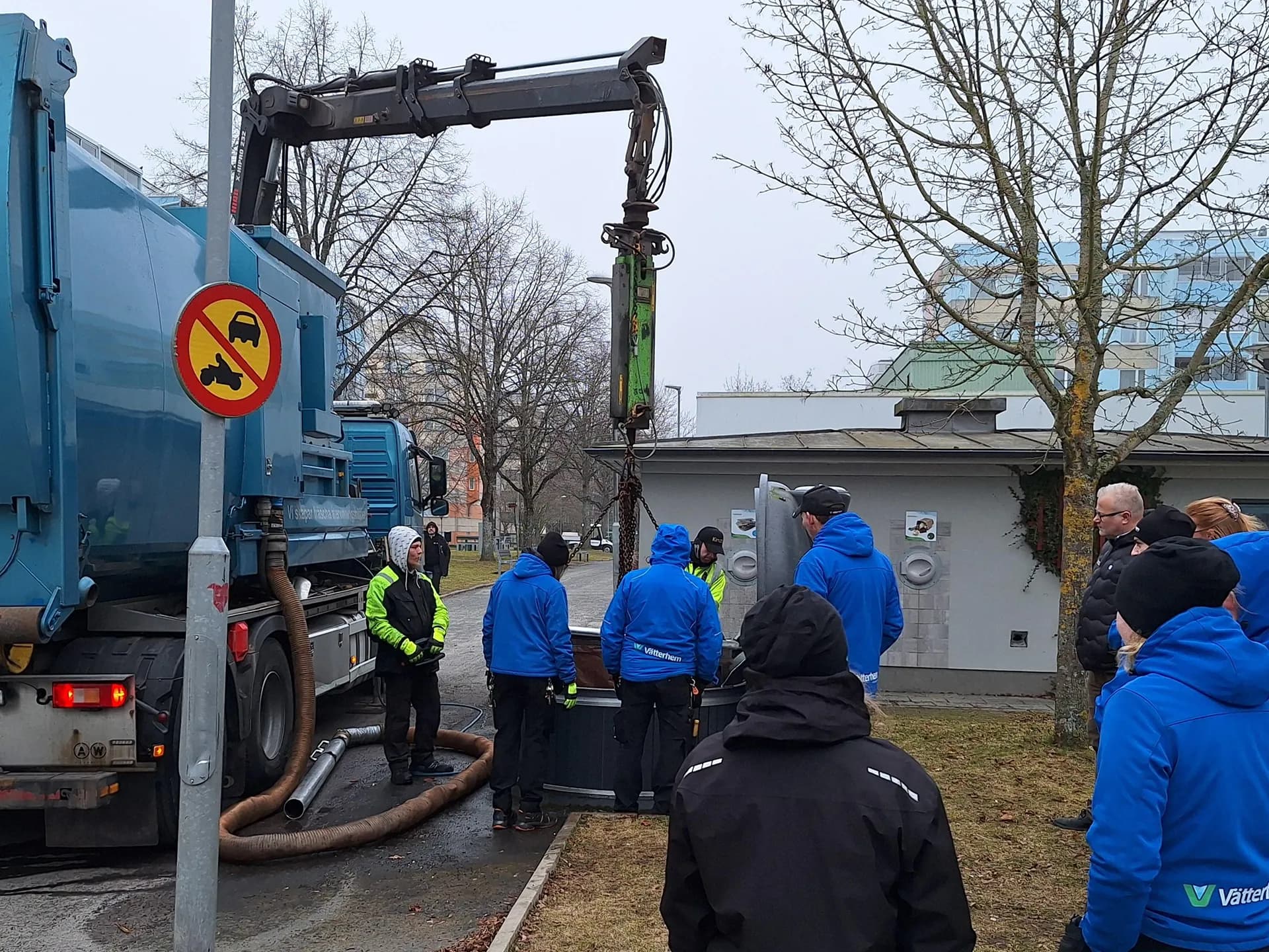 Kranbil som tömmer bottentömda, nedsänkta sopkärl i Vätterhems bostadsområde